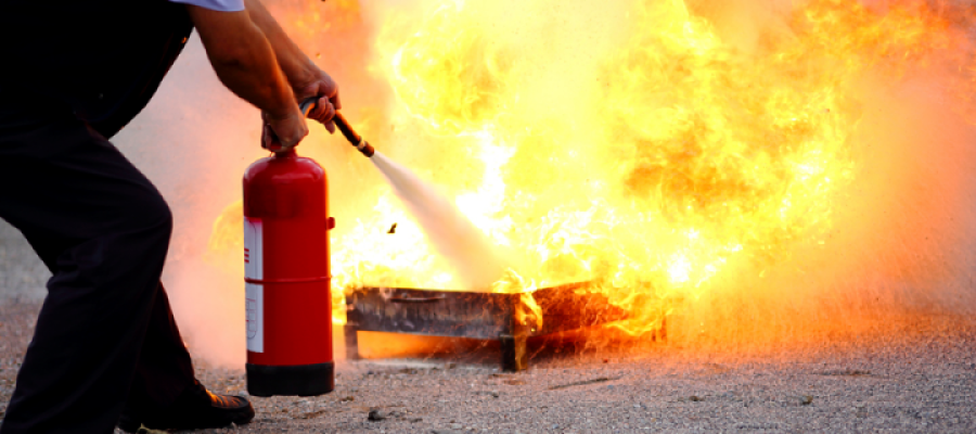 Fire extinguisher being used on large flames