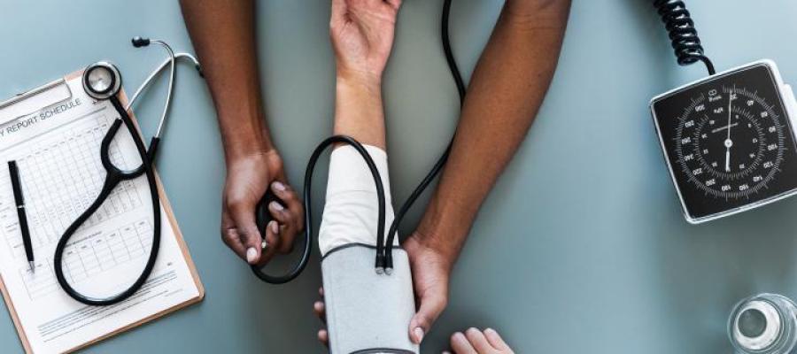 A doctor and patient's arms as blood pressure is taken